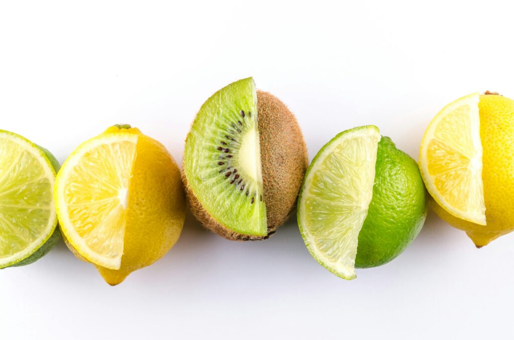 Colorful arrangement of kiwi, lemon, and lime slices showcasing freshness and vibrancy on a white background.